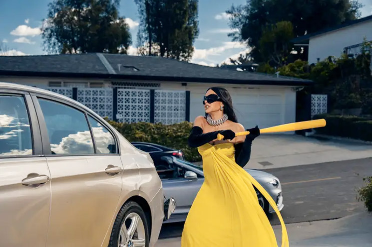 Photo of Kim Kardashian swinging a bat at a car