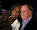 Doug Jones takes a selfie with a supporter during a get out the vote campaign rally