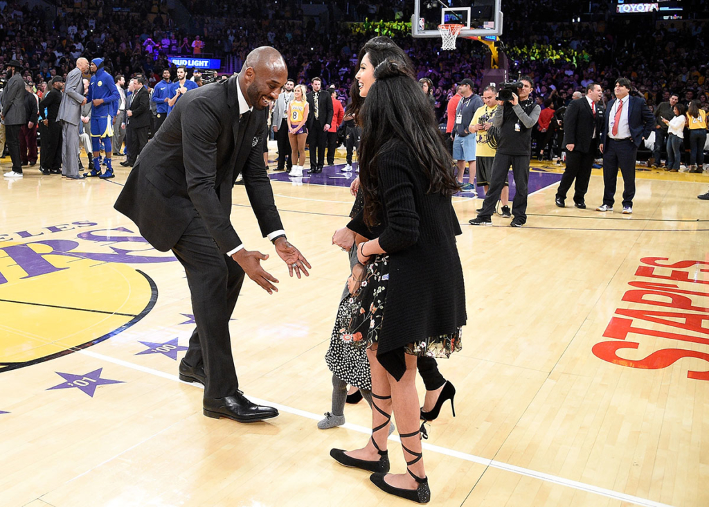 Kobe Bryant runs after his family at halftime after both his #8 and #24 Los Angeles Lakers jerseys are retired