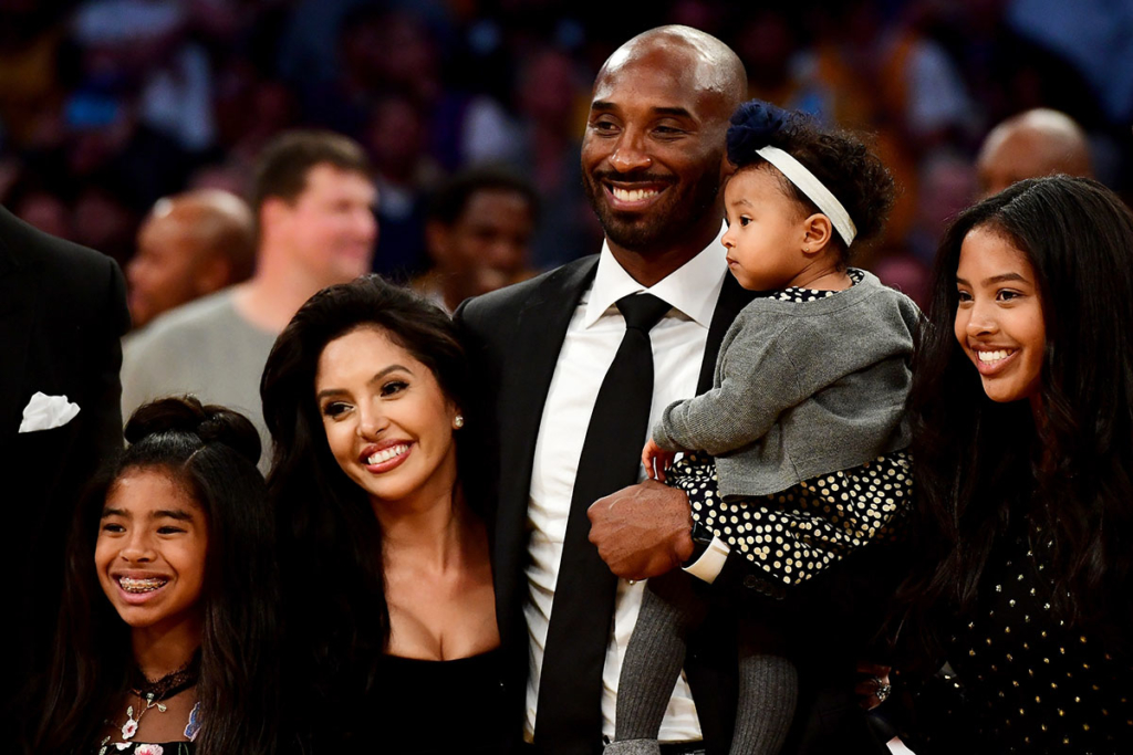 Kobe Bryant poses with his family at halftime after both his #8 and #24 Los Angeles Lakers jerseys are retired