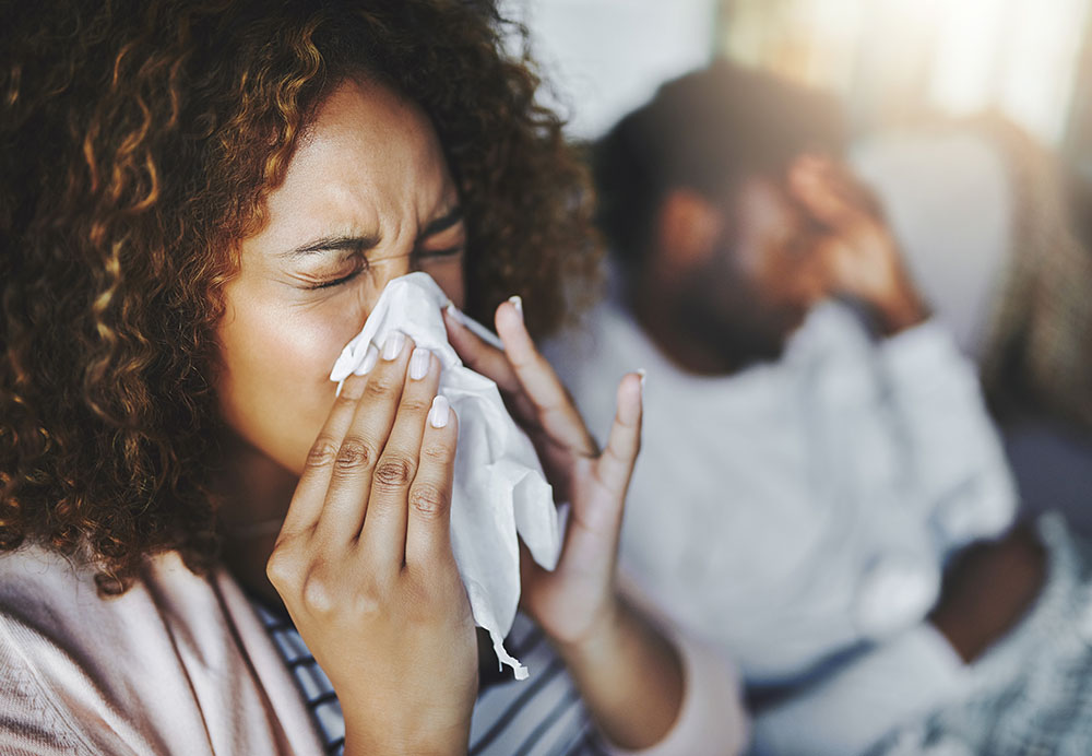 Young woman blowing her nose with her boyfriend