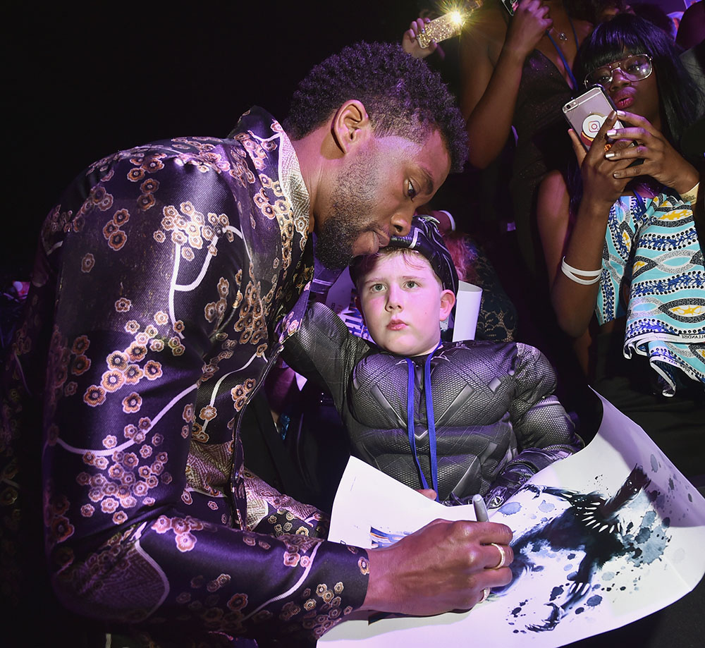 Chadwick Boseman signs autograph for young fan at the LA Premiere of Black Panther