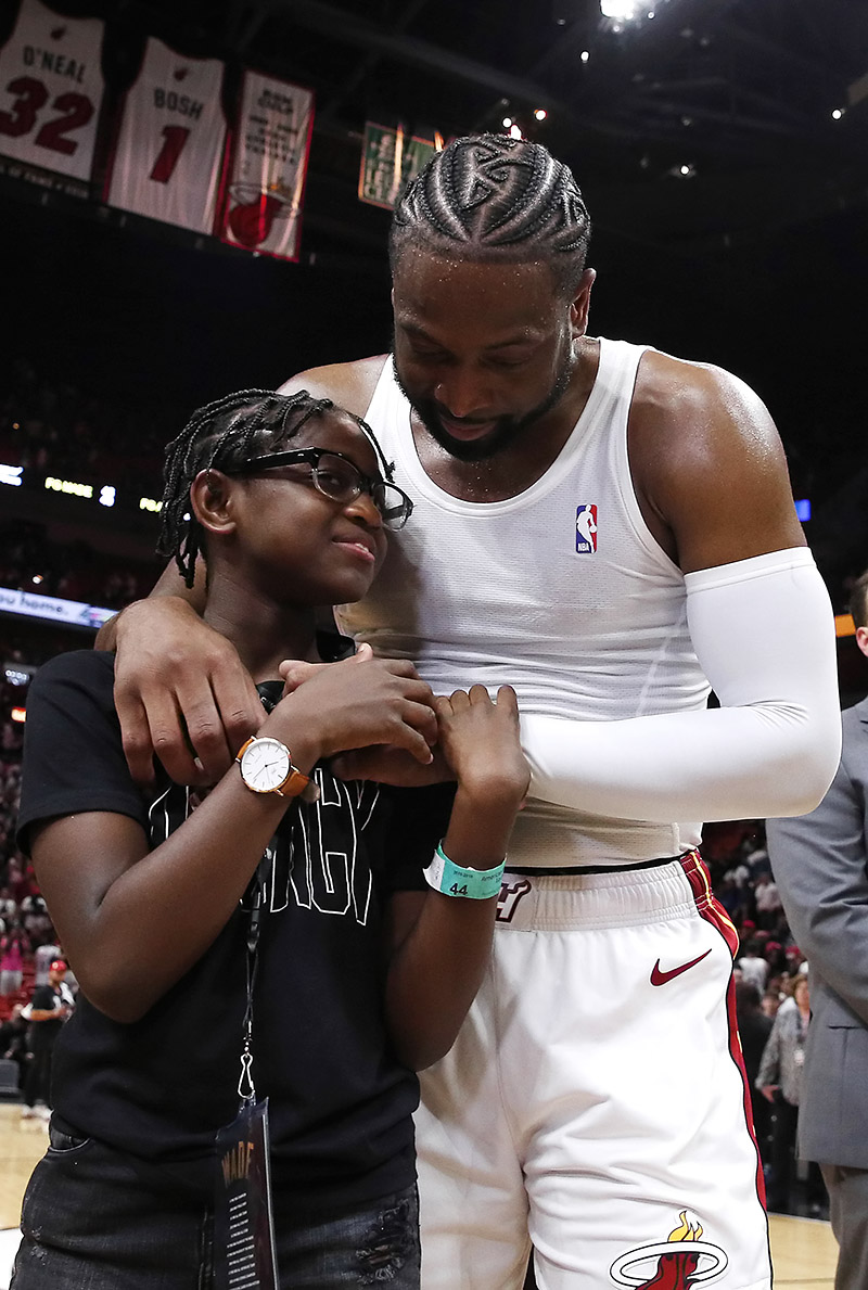 Dwyane Wade #3 of the Miami Heat hugs his son, Zion Wade, after his